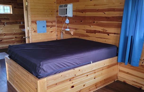 accessible family cabin queen bed with air conditioner at Adventure Bound Beaver Trails